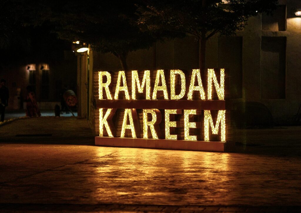Podświetlany napis Ramadan Kareem ustawiony na ulicy w Egipcie nocą
