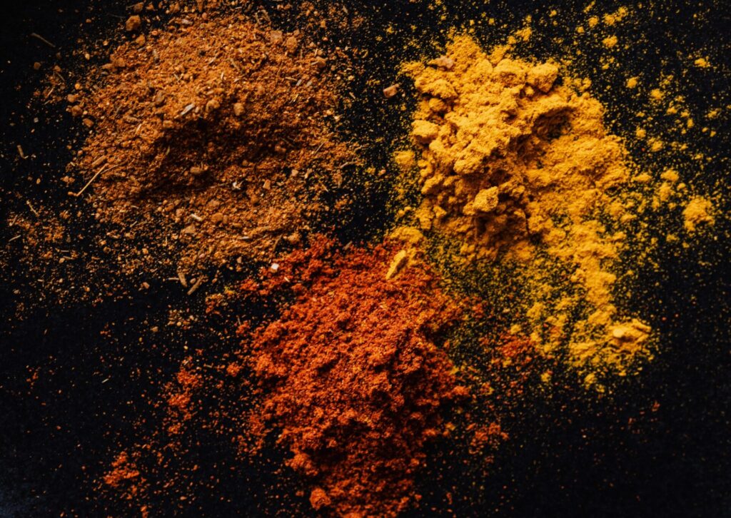 Arabskie przyprawy w proszku – kurkuma, papryka i mieszanki korzenne na ciemnym tle