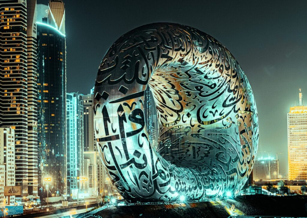 Museum of the Future w Dubaju oświetlone nocą na tle nowoczesnych wieżowców