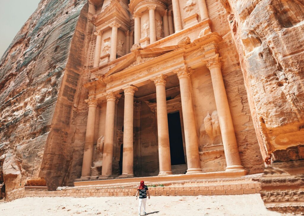 Turysta stojący przed monumentalnym Skarbcem w Petrze w Jordanii