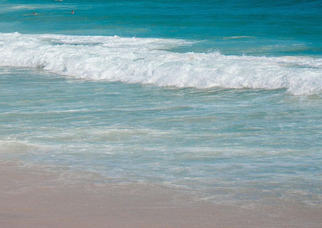Fale morskie rozbijające się o brzeg na piaszczystej plaży w Hiszpanii