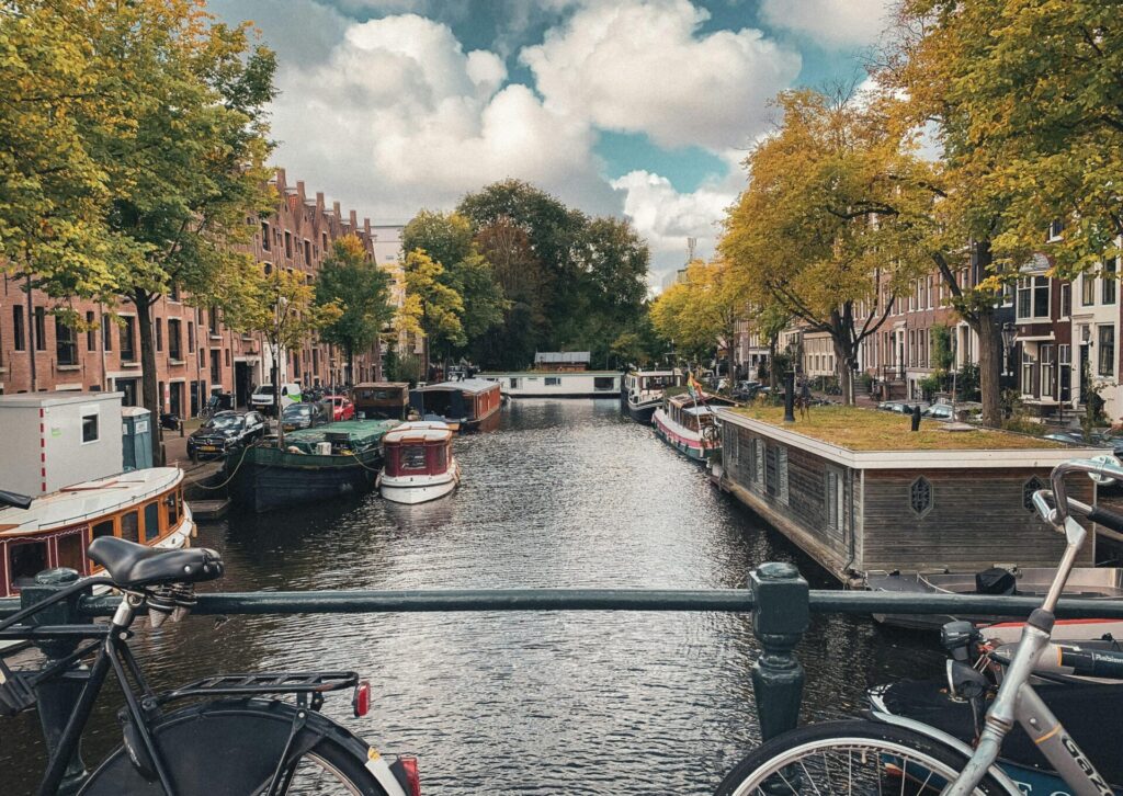 Kanał w centrum Amsterdamu z rowerami na moście i zabytkowymi kamienicami