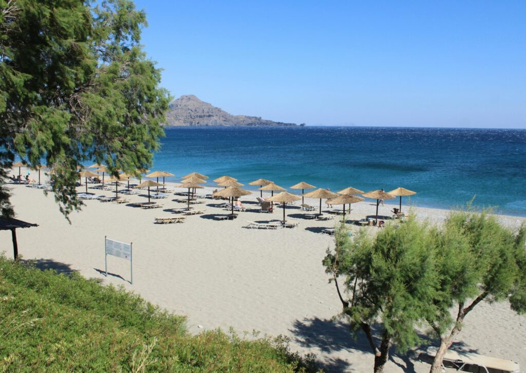 Majówka na Rodos – piaszczysta plaża z parasolami nad Morzem Egejskim