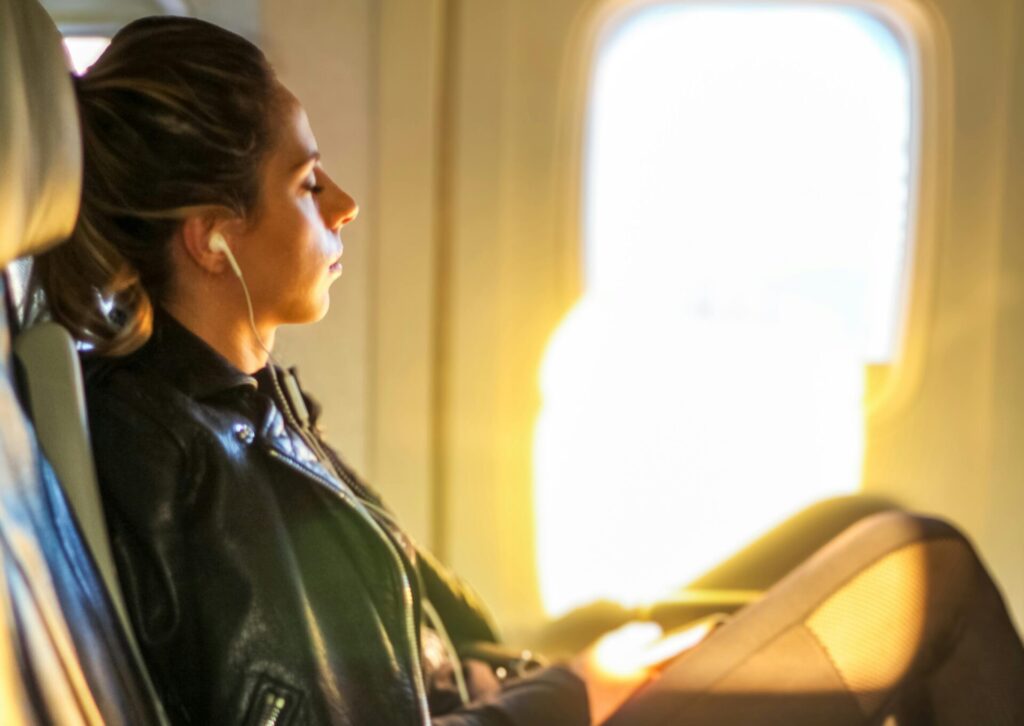 Pasażerka odpoczywająca w samolocie podczas długiego lotu i walki z jet lag