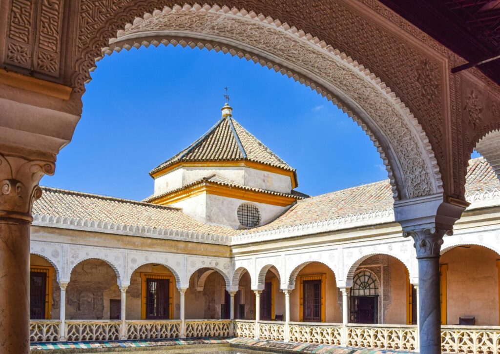 Dziedziniec pałacu Real Alcázar w Sewilli z arkadami i dekoracyjnymi zdobieniami