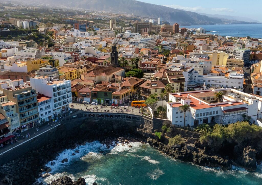 Widok na Puerto de la Cruz na Teneryfie z zabudową nad oceanem i górskim krajobrazem
