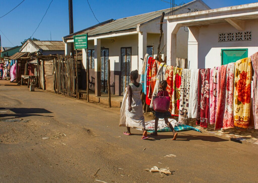 Ulica na Madagaskarze i mieszkańcy przechodzący obok domów