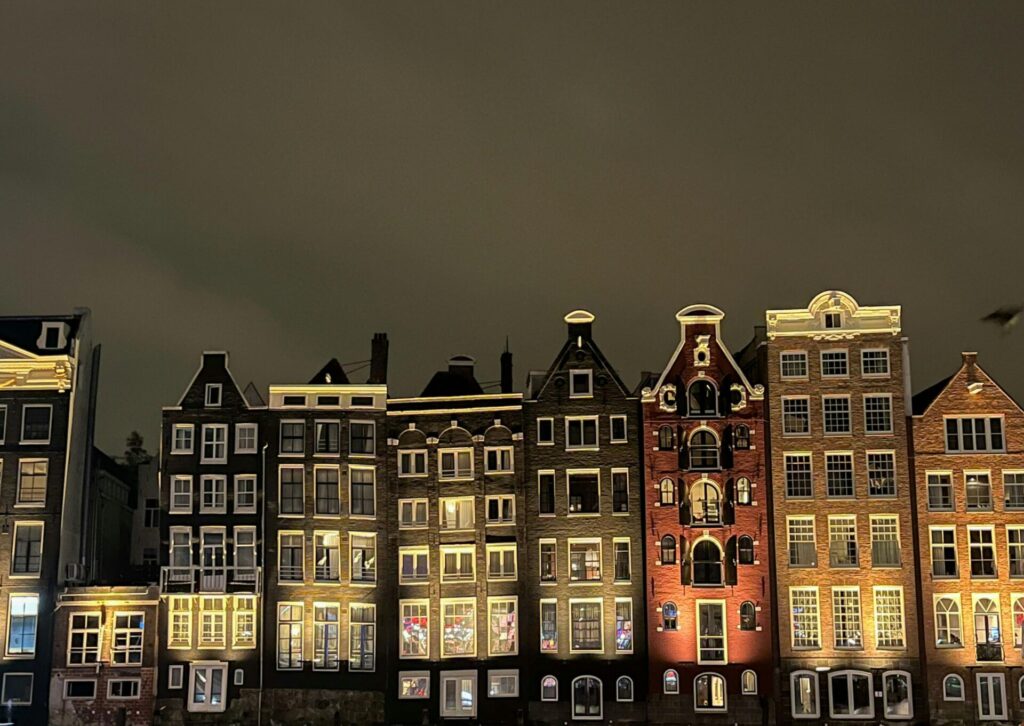 Zabytkowe kamienice nad kanałem w Amsterdamie nocą