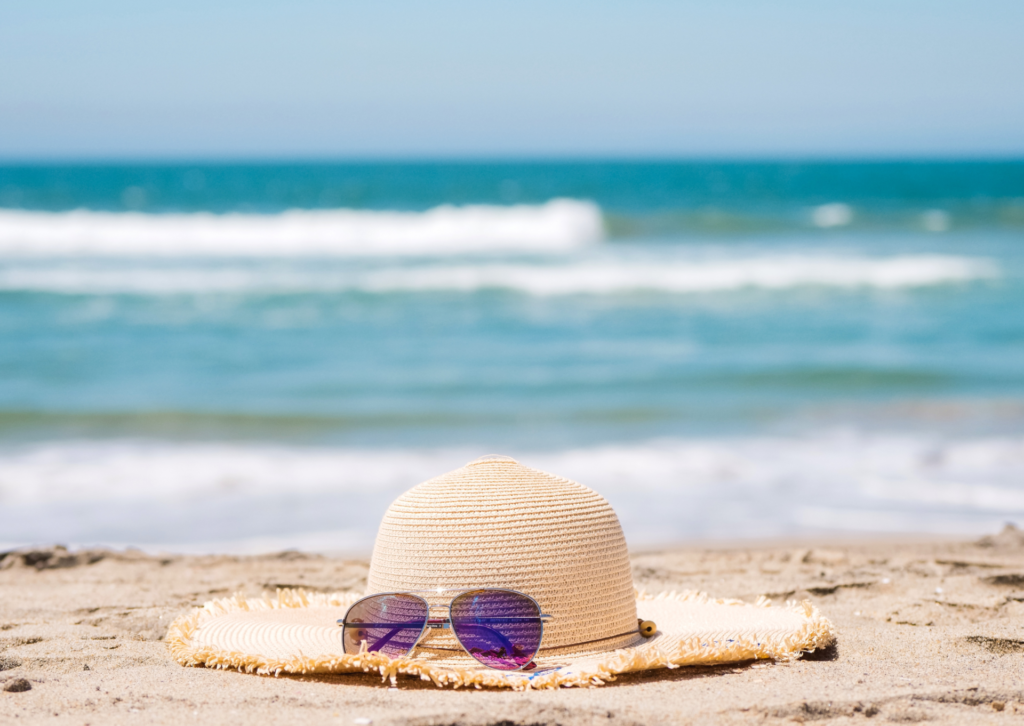 Kapelusz i okulary przeciwsłoneczne na plaży z widokiem na morze w Hiszpanii