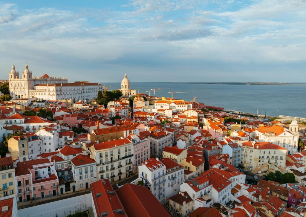 Panorama Lizbony z czerwonymi dachami i widokiem na ocean