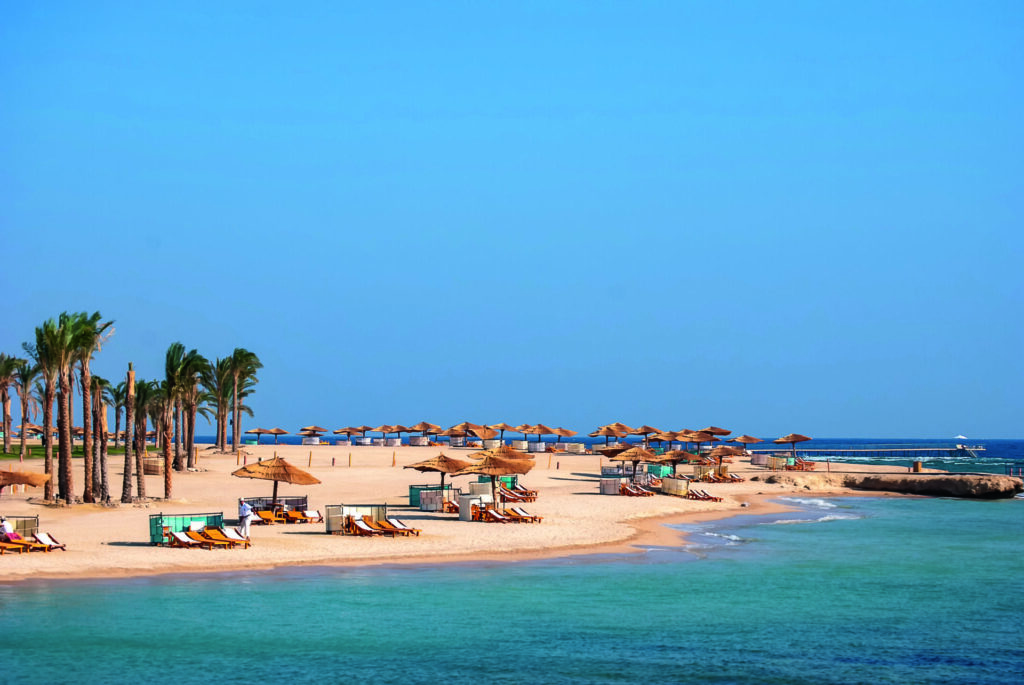 Plaża z turkusową wodą i leżakami w Egipcie